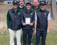 MCC's golf team standing outside holding their invitational win plaque.