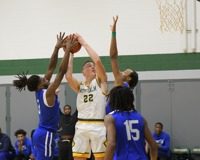 MCC Basketball Player surrounded and playing on the court.