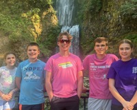 Image of Athlete Ryan Hardy and others in front of waterfall.