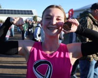 MCC Student with a pink out t-shirt smiling and posing.