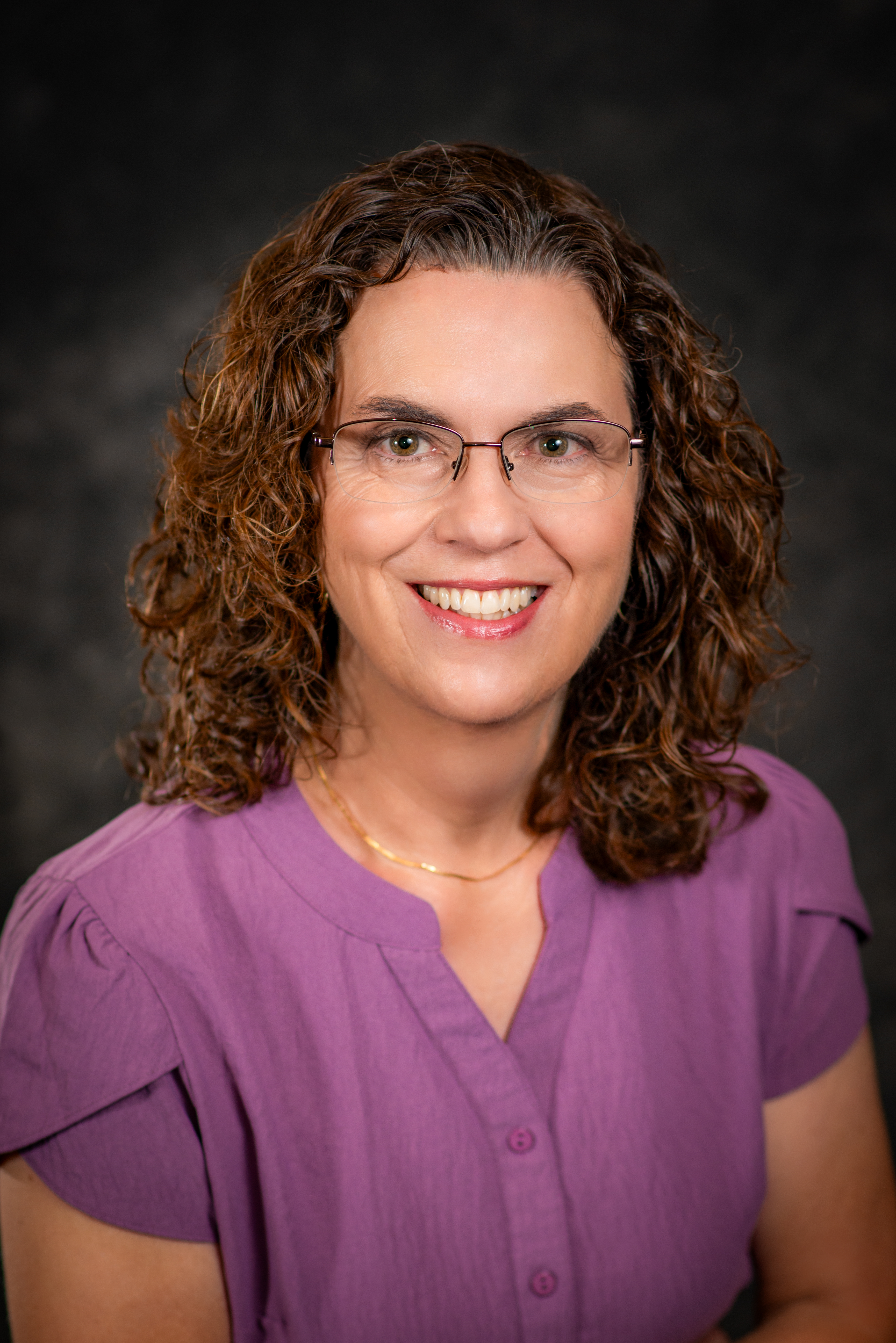 Professional photo of Teresa Snyder wearing a purple shirt and smiling at the camera.